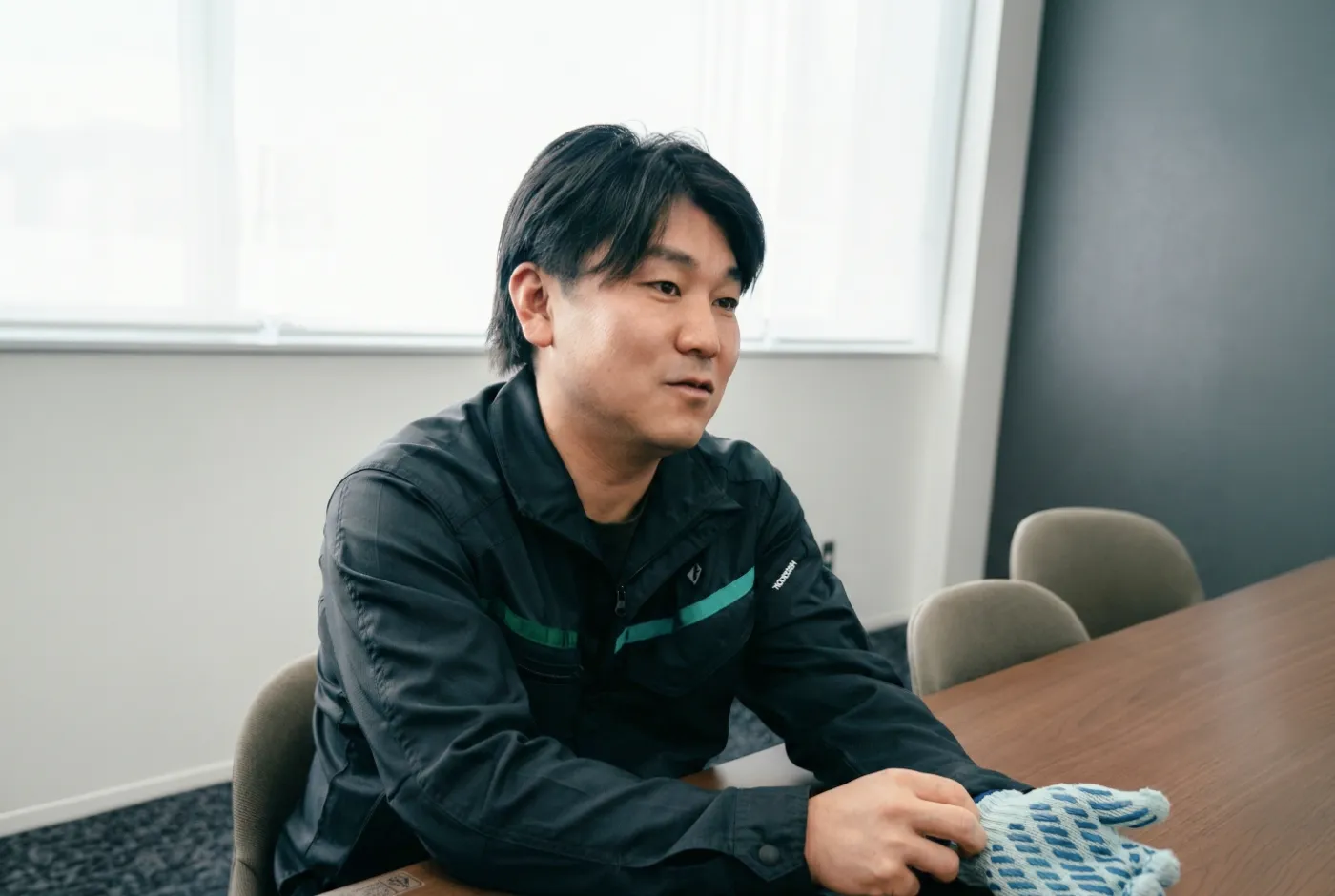 アップサイクルした軍手を手に当時を振り返るカモ井加工紙株式会社の担当者
