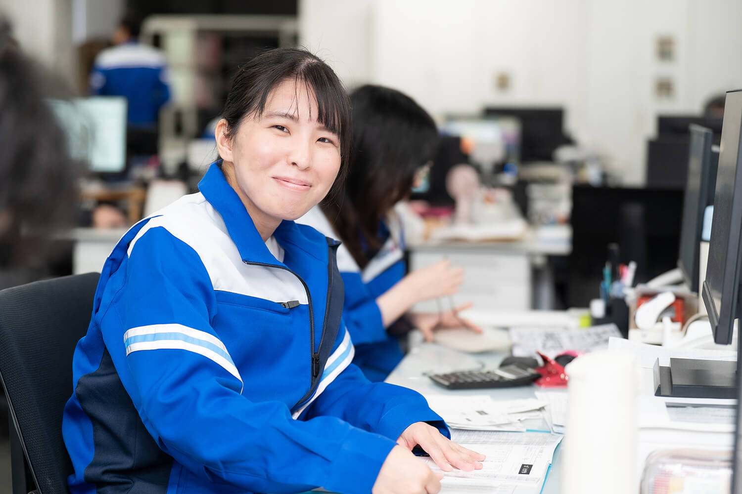 トラックの前に立つ社員